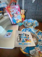 All items grouped: Goofy Treasures tin, Mickey DVD, Mickey figurine, souvenir tray, round pin