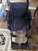 Top front view of wheelchair showing seat, armrests, footrests