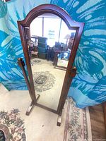Front view showing full-length mahogany cheval mirror with arched top and tilting side supports