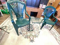 Overall view of both plastic chairs and metal mesh side table on rug