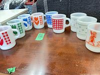 Group shot of all nine Termocrisa milk glass mugs showing design variety