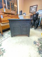 Front view of black solid wood cabinet, doors closed