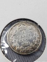 reverse of 1910 5-cent coin showing crown, wreath, denomination, date
