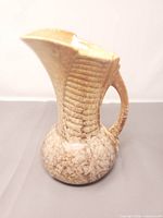 Front view of mottled glaze Sylvac pitcher showing flared spout and ribbed body