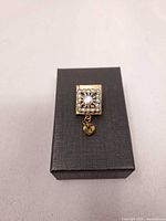 brooch closed on box, rhinestone cover visible