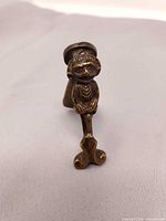 Front view of brass Lincoln Imp door knocker, showing figure and striker