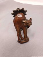 Front view of brass cat door knocker standing upright