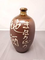 Full front view of stoneware vase showing form and characters