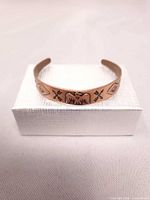 Full view of copper cuff on gift box showing design