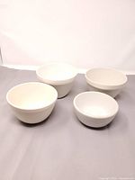 Set of four nested white ceramic bowls