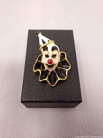 Front view of clown brooch on gift box