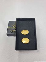 cufflinks in open box beside lid