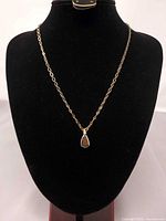 Full view of necklace on display bust showing chain length and pendant size