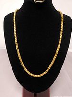 Full view of gold wheat link chain necklace on display bust