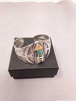 Front view of silver cuff showing inlay arrow and stamp work