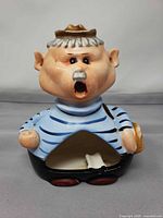 Full view of ceramic ashtray figure showing shape and open belly