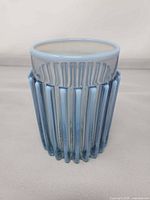 Full view of pale blue opalescent ribbed tumbler standing upright