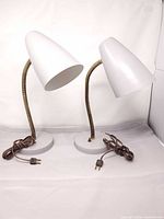 Pair of matching grey metal gooseneck lamps with cords visible
