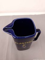 Top view showing dark blue ceramic interior, square rim and pouring spout