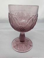 Full view of purple pressed glass goblet showing bowl, stem, and foot