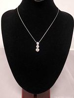 Full view of necklace on display bust showing chain length and pendant drop