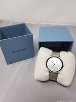 Watch on cushion next to blue Skagen box