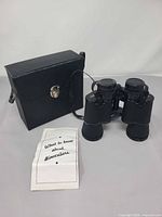Binoculars, closed case, and manual displayed together