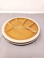 Stacked view of two ochre glazed divided plates showing top surface and rim
