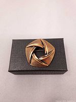 front view of pentagon copper brooch on gift box