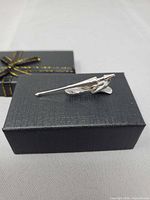 Tie clip displayed on top of gift box, angled view