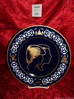 Front view of cobalt blue commemorative plate with gold silhouettes, white lattice rim, date 1981
