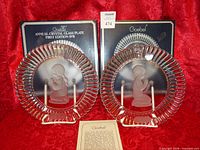 Both annual crystal plates on stands with boxes and paperwork visible