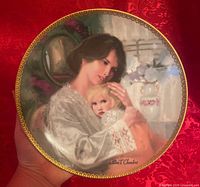 Front view of porcelain plate showing artwork and gold border