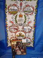 Tea towel with printed 1977 Jubilee design, tin and spoon in foreground