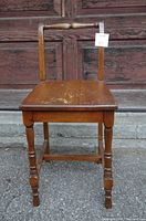 front view of wooden vanity chair showing overall design and wear on seat