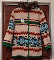 Front view of Benetton wool coat showing pattern, buttons, pockets, and faux-fur hood trim