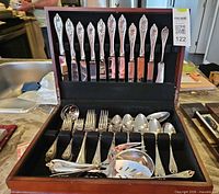 Full view of open chest showing knives in lid and assorted flatware in drawer