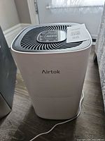 Front and side view of Airtok AP1001 air purifier with cord connected