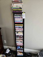 Full view of tall black media tower filled with DVD cases