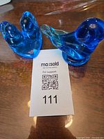 Pair of blue glass bird figurines with auction tag