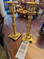 Front view of both brass candlesticks on table