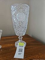 Full view of clear cut crystal pedestal vase on wood surface