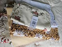 Stack of assorted embroidered linens with tag visible
