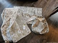Quilt/coverlet folded with two pillow shams on floor