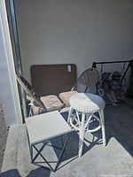 Overall lot showing folding chairs, folding card table, wicker stool and stone-top side table