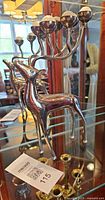 Front view of chrome reindeer candelabra displaying four candle cups