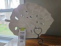 Front view of cream ceramic leaf plate on heart easel