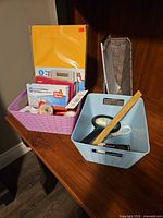 Baskets with assorted office supplies on table