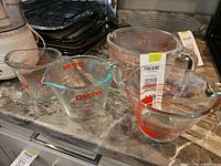 Group shot of four Pyrex glass measuring cups, showing overall lot contents