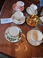 Six assorted bone china teacup and saucer sets arranged on table